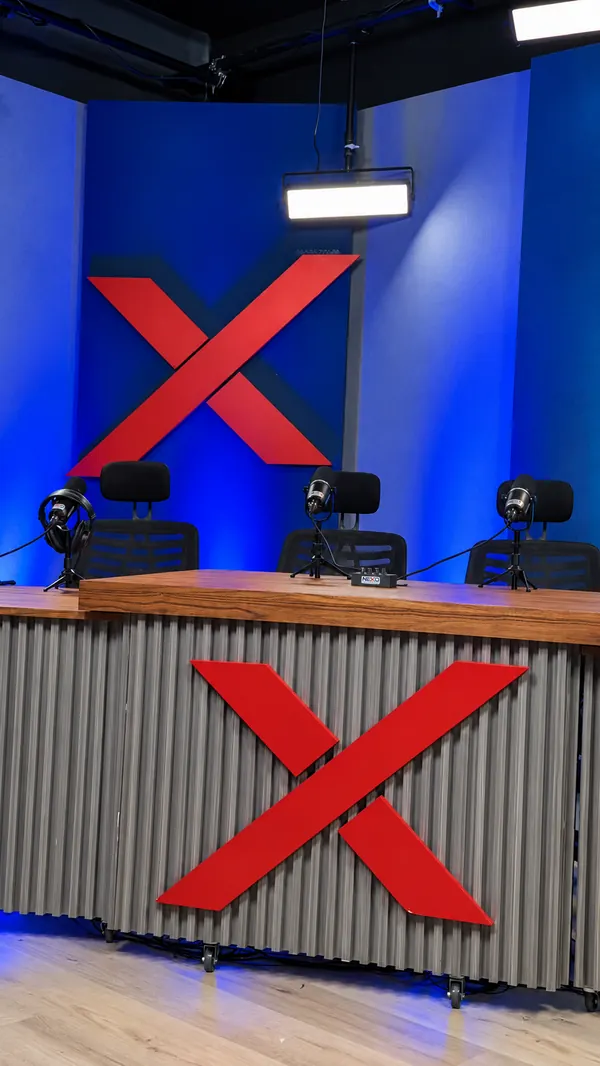 La mesa de conducción de NEXO Studios con la X roja y los micrófonos