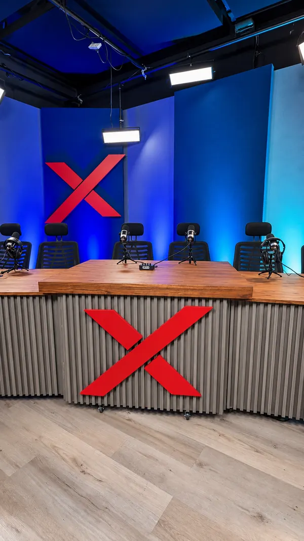 Mesa de conducción con la X roja y cinco puestos con micrófono