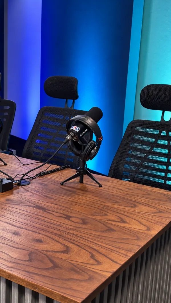 Detalle de micrófono con auriculares sobre la mesa de madera